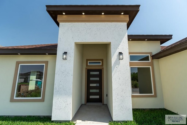 view of exterior entry featuring stucco siding