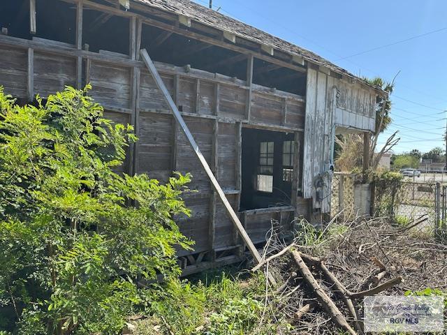 view of side of home featuring an outdoor structure and fence