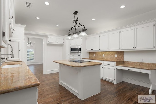 kitchen featuring white cabinets, dark hardwood / wood-style floors, a kitchen island, and stainless steel microwave