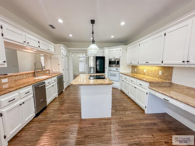 kitchen with white cabinetry, stainless steel microwave, dark wood-type flooring, white oven, and pendant lighting