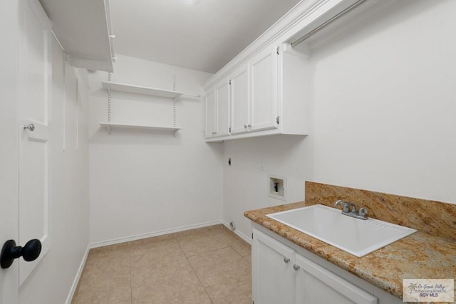 washroom with cabinets, sink, light tile patterned floors, and washer hookup