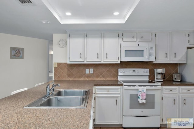 406 Padre Blvd Unit 207, South Padre Island, TX 78597 - kitchen with white appliances, recessed lighting, a tray ceiling, backsplash, and white cabinetry