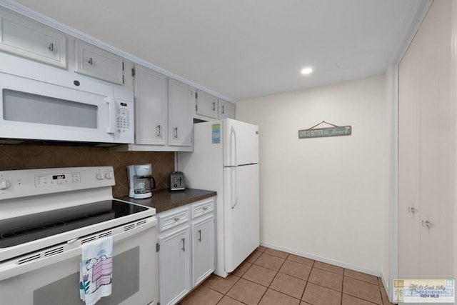 406 Padre Blvd Unit 207, South Padre Island, TX 78597 - kitchen featuring white appliances, decorative backsplash, light tile patterned floors, dark countertops, and recessed lighting