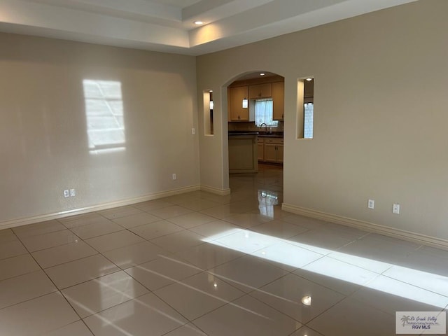 empty room with light tile patterned flooring and sink