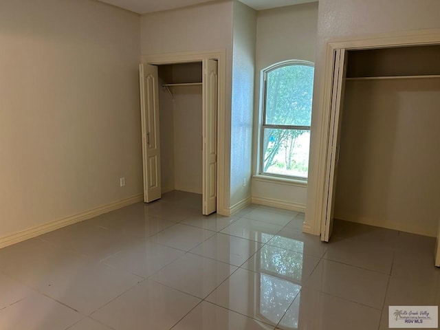 unfurnished bedroom featuring light tile patterned flooring and a closet