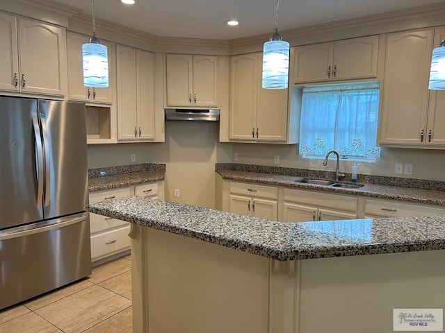 kitchen featuring sink, stainless steel fridge, dark stone counters, pendant lighting, and light tile patterned floors