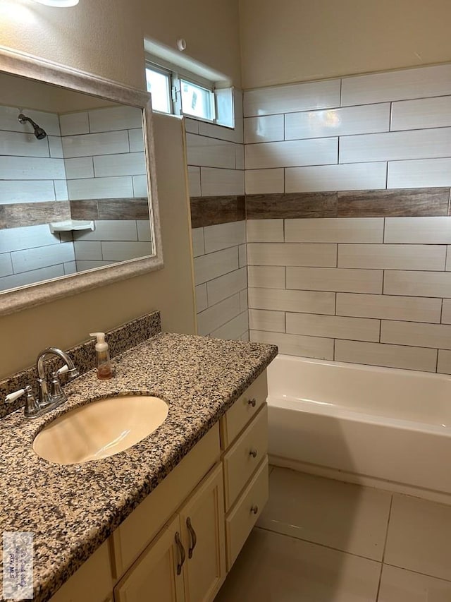 bathroom with tile patterned flooring, tiled shower / bath combo, and vanity