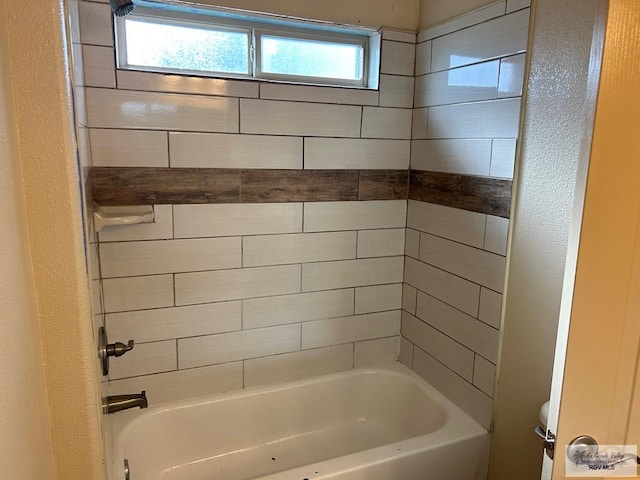 bathroom featuring toilet, tiled shower / bath, and a healthy amount of sunlight