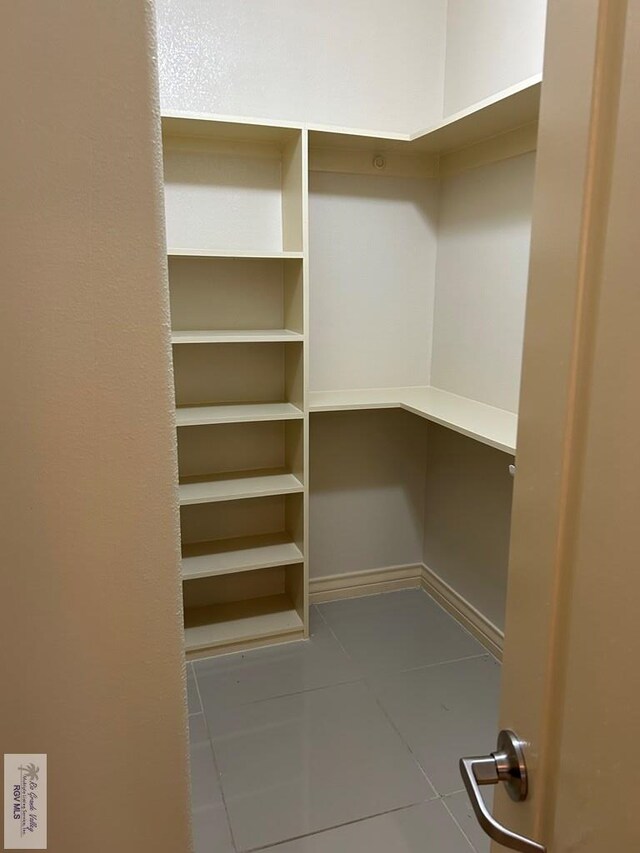 spacious closet with light tile patterned floors