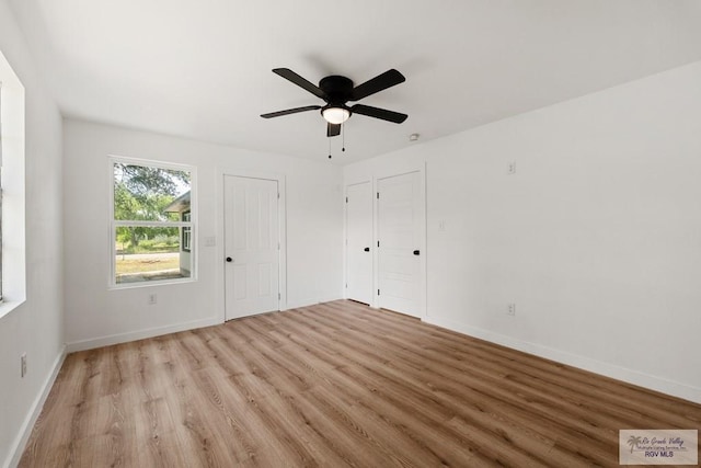 empty room with ceiling fan and light hardwood / wood-style flooring