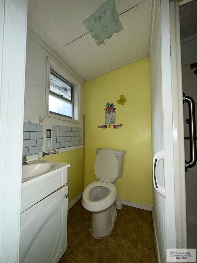 bathroom featuring tasteful backsplash, tile patterned flooring, vanity, and toilet