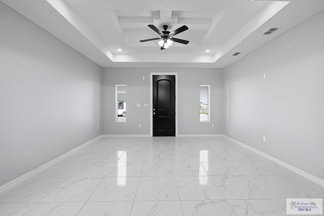 unfurnished room featuring ceiling fan and a raised ceiling