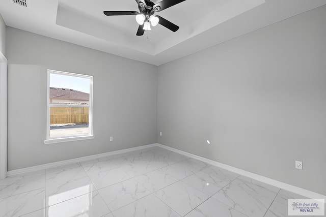 unfurnished room with a raised ceiling and ceiling fan