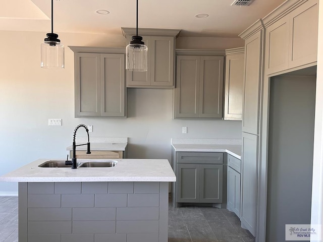 kitchen with sink, gray cabinets, hanging light fixtures, and dark tile patterned floors