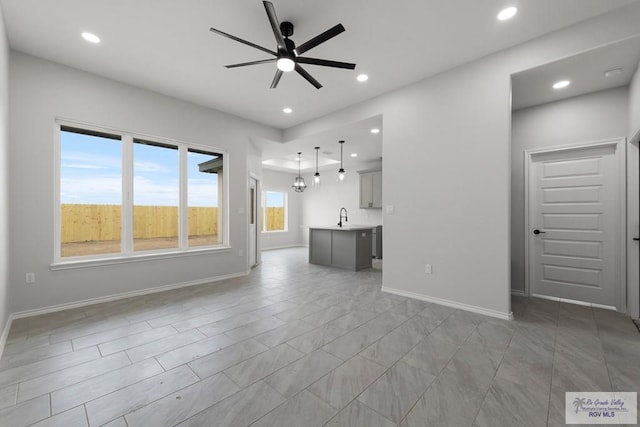 unfurnished living room featuring sink and ceiling fan