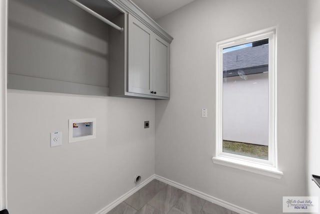 clothes washing area with electric dryer hookup, hookup for a washing machine, and cabinets