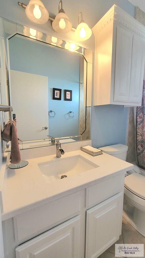 bathroom featuring tile patterned flooring, vanity, and toilet