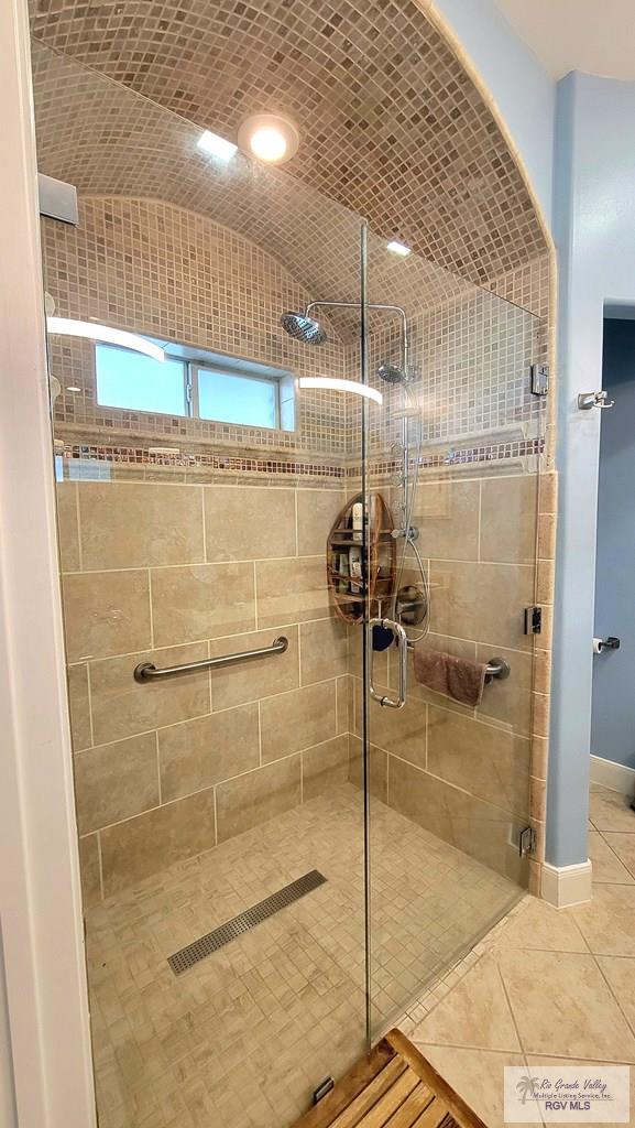 bathroom featuring tile patterned floors, an enclosed shower, and lofted ceiling