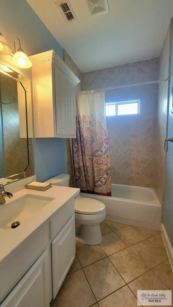 full bathroom featuring toilet, vanity, tile patterned floors, and shower / bath combo with shower curtain