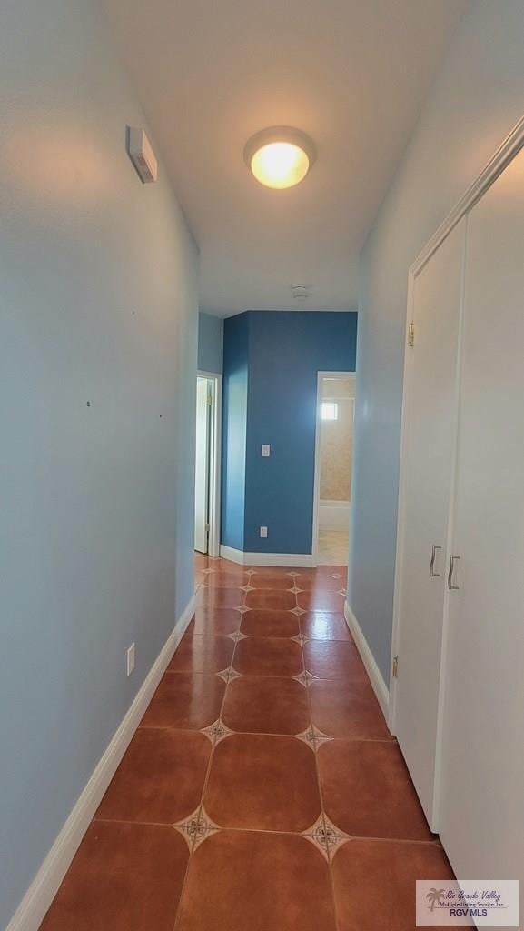 hall with tile patterned floors