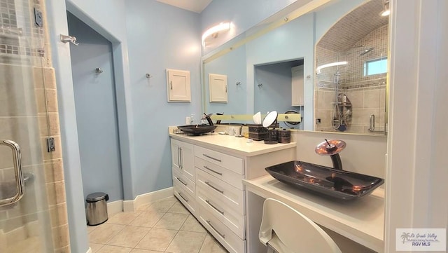 bathroom featuring tile patterned flooring, vanity, and a shower with shower door