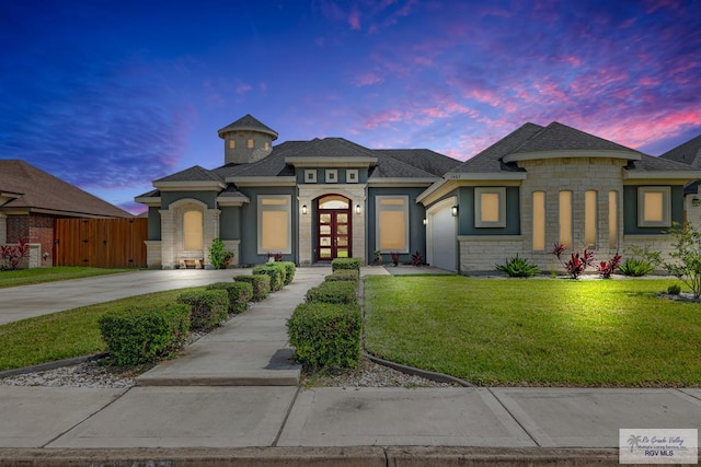 view of front of home featuring a lawn, a garage, and french doors