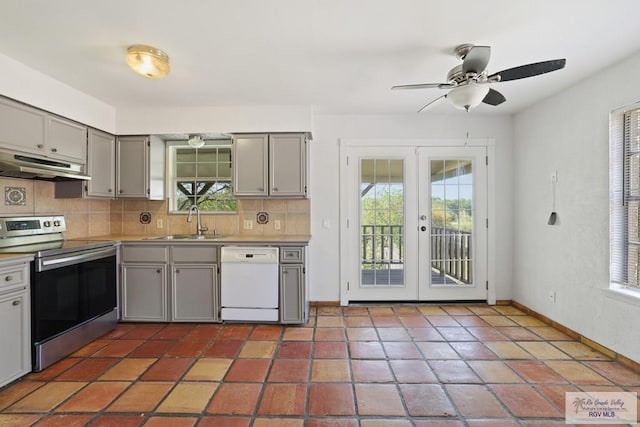 kitchen featuring gray cabinetry, under cabinet range hood, stainless steel range with electric cooktop, white dishwasher, and a sink