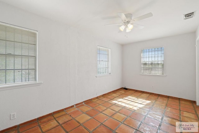 spare room featuring visible vents and a ceiling fan