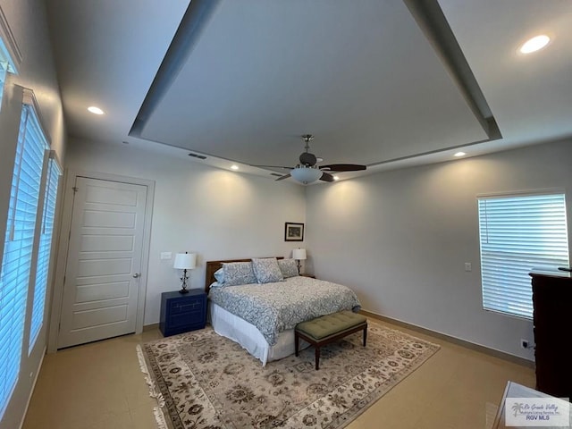 bedroom featuring a raised ceiling and ceiling fan