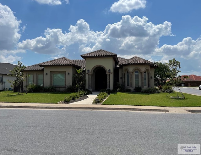 mediterranean / spanish house featuring a front yard