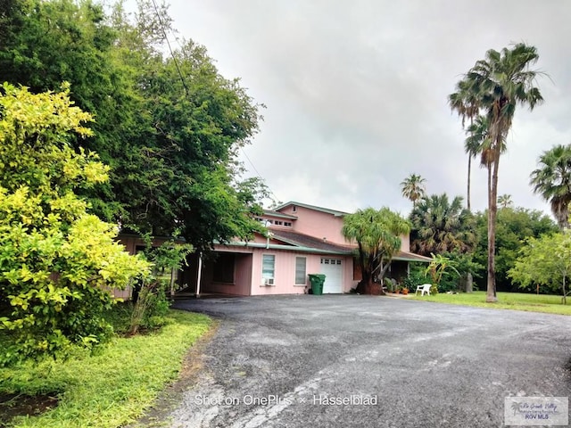 view of front facade with a garage and aphalt driveway