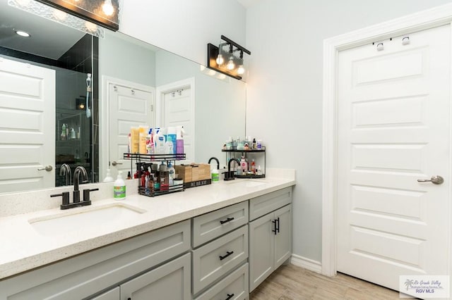 bathroom featuring hardwood / wood-style flooring, vanity, and a shower with door