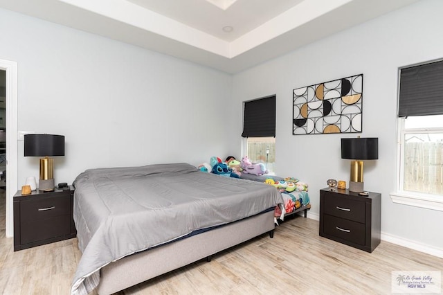 bedroom featuring multiple windows and light hardwood / wood-style flooring