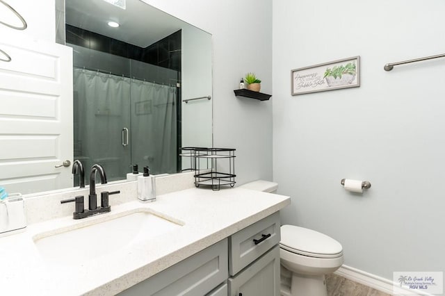 bathroom featuring a shower with curtain, hardwood / wood-style flooring, vanity, and toilet