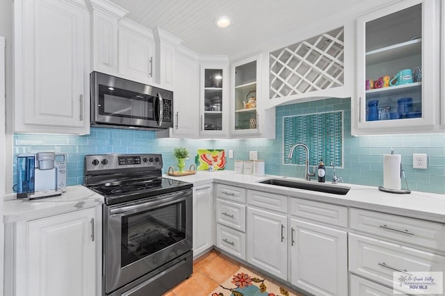 kitchen featuring light tile patterned flooring, sink, white cabinetry, and stainless steel appliances