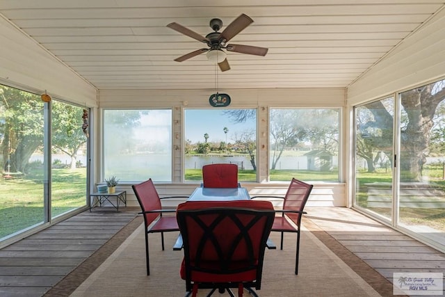 sunroom with a water view, vaulted ceiling, and ceiling fan