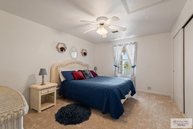 bedroom featuring attic access, visible vents, ceiling fan, carpet floors, and a closet