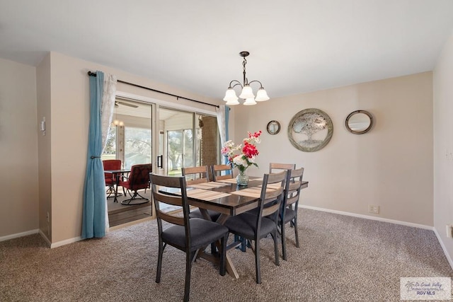 carpeted dining room featuring a chandelier and baseboards