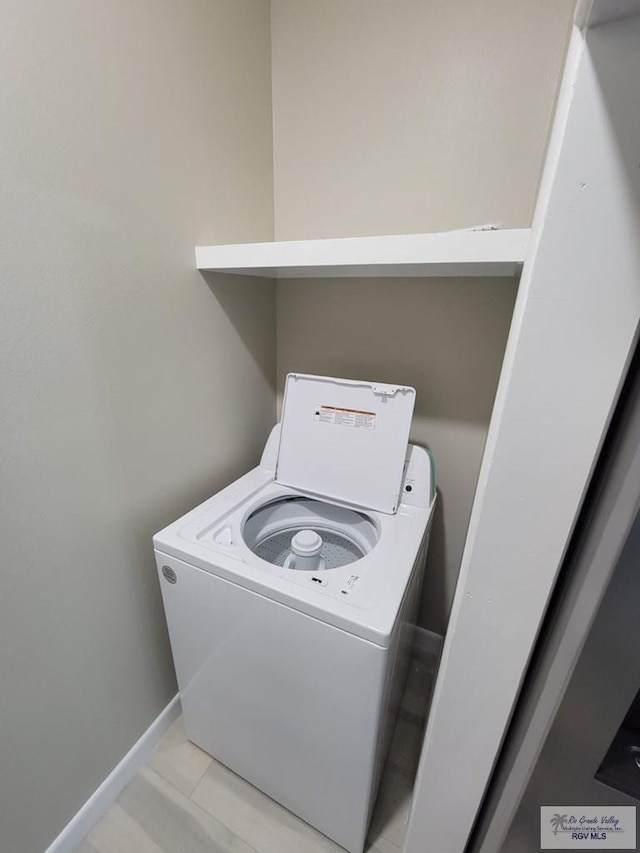 laundry area featuring light tile patterned flooring and washer / dryer