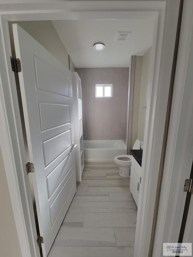 full bathroom with vanity, toilet, and tiled shower / bath