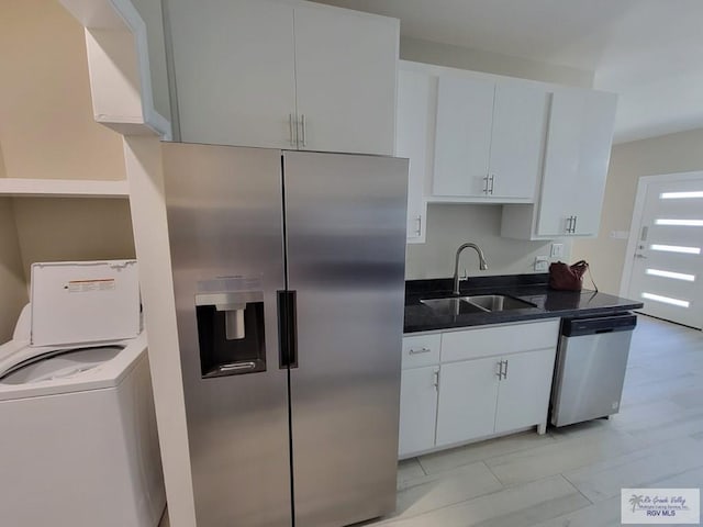 kitchen featuring washer / clothes dryer, sink, white cabinets, and stainless steel appliances