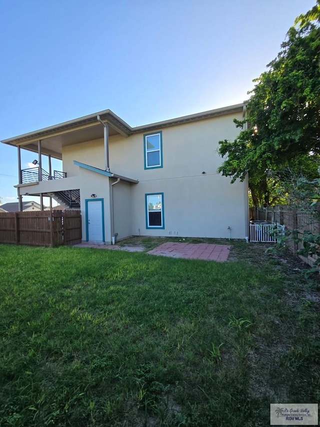 rear view of property featuring a lawn