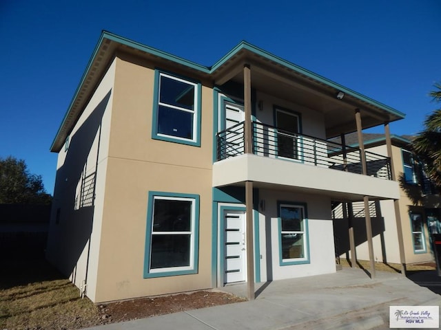 rear view of property with a patio area and a balcony