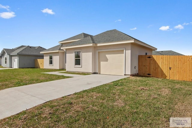 prairie-style house with fence, concrete driveway, a front yard, stucco siding, and a garage