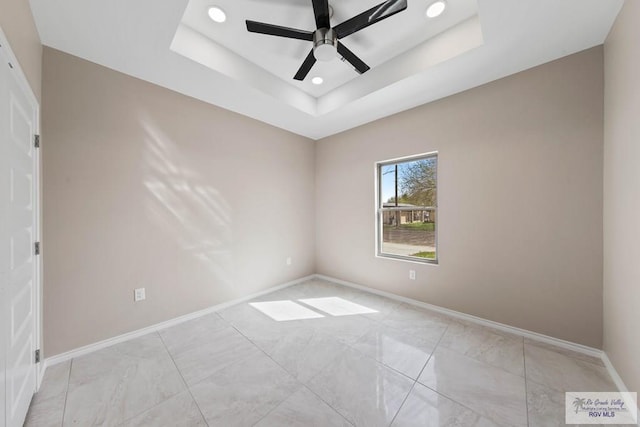 unfurnished room with recessed lighting, a ceiling fan, a raised ceiling, and baseboards