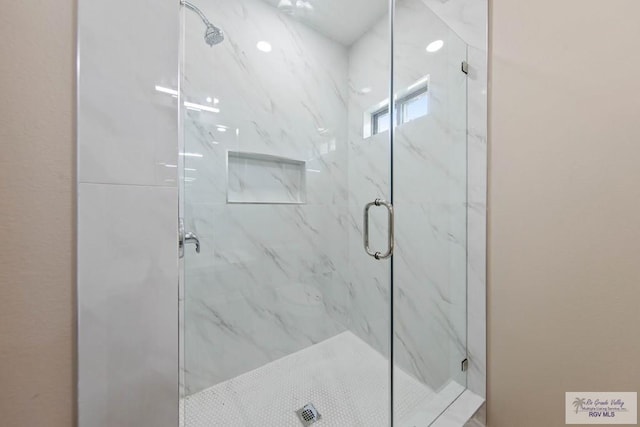 bathroom featuring a marble finish shower