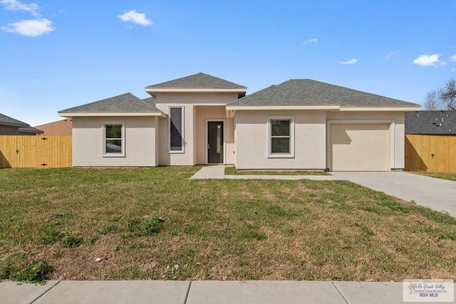 prairie-style home featuring a front lawn, fence, stucco siding, driveway, and an attached garage