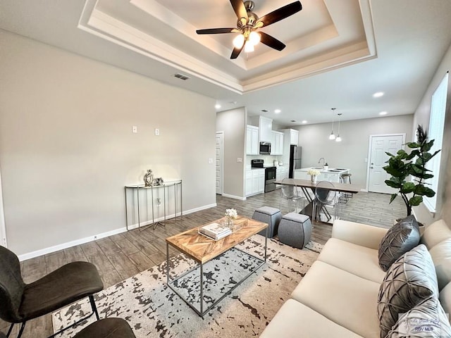 1505 Shavano Dr, Edinburg, TX 78541 - living area featuring a raised ceiling, wood finished floors, a ceiling fan, baseboards, and recessed lighting