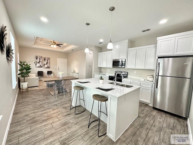 1505 Shavano Dr, Edinburg, TX 78541 - kitchen with appliances with stainless steel finishes, light wood-type flooring, light countertops, white cabinets, and recessed lighting