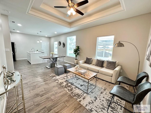 1505 Shavano Dr, Edinburg, TX 78541 - living area featuring light wood-style floors, a tray ceiling, ceiling fan, baseboards, and recessed lighting